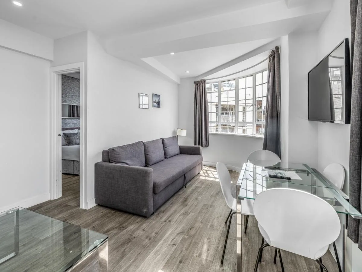 Living room with sofa and glass table at Chelsea Cloisters Serviced Apartments near Sloane Avenue