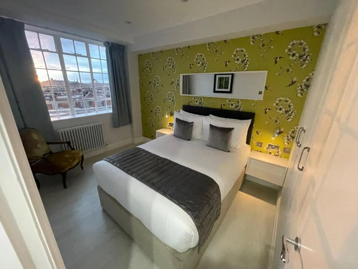 Bedroom with yellow wall at Chelsea Cloisters Serviced Apartments in London